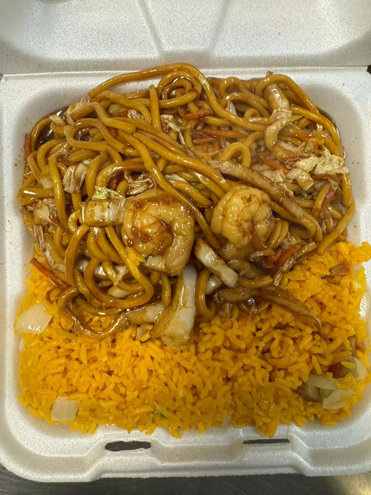 Lo mein with shrimp, cabbage, and carrots over yellow rice