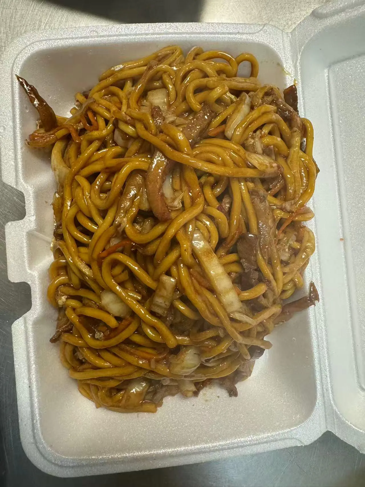 Stir-fried noodles with meat and cabbage in a takeout box